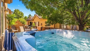 A backyard with a hot tub, patio furniture, and a tree providing shade. - Coral Ridge 4144, Hot Tub, Bikes, Scooters, and near Coral Canyon Golf Course, SLP 12 (Washington)