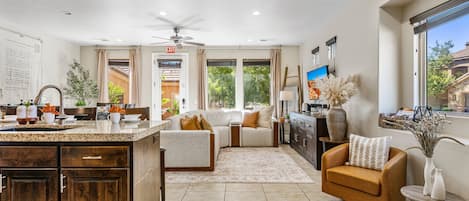 Un salón espacioso con cocina, un sofá, una mesa de centro y un televisor.