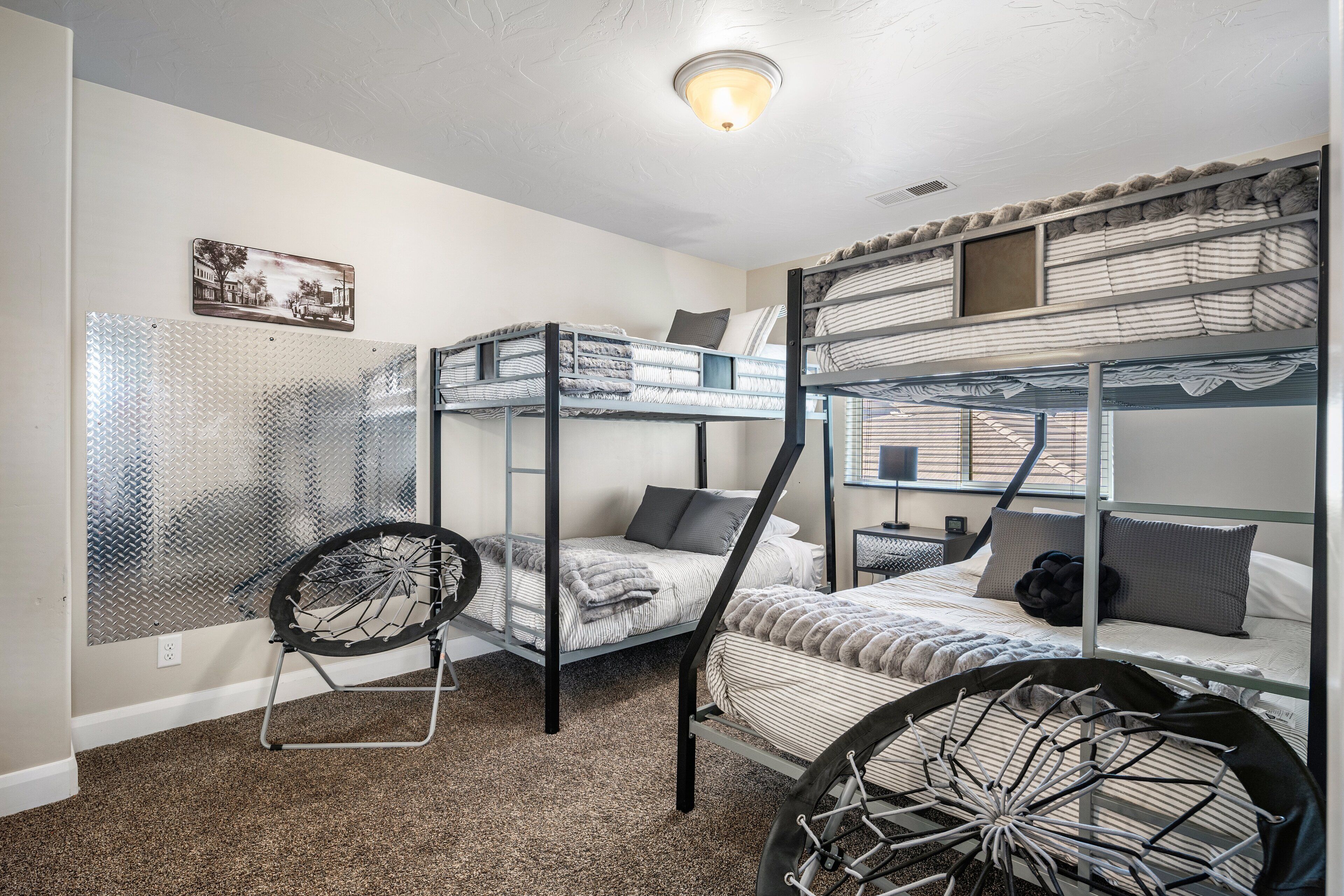 Quarto com beliche, uma escada de metal, cadeira de rodas com roda de bicicleta e espelho fixado na parede.