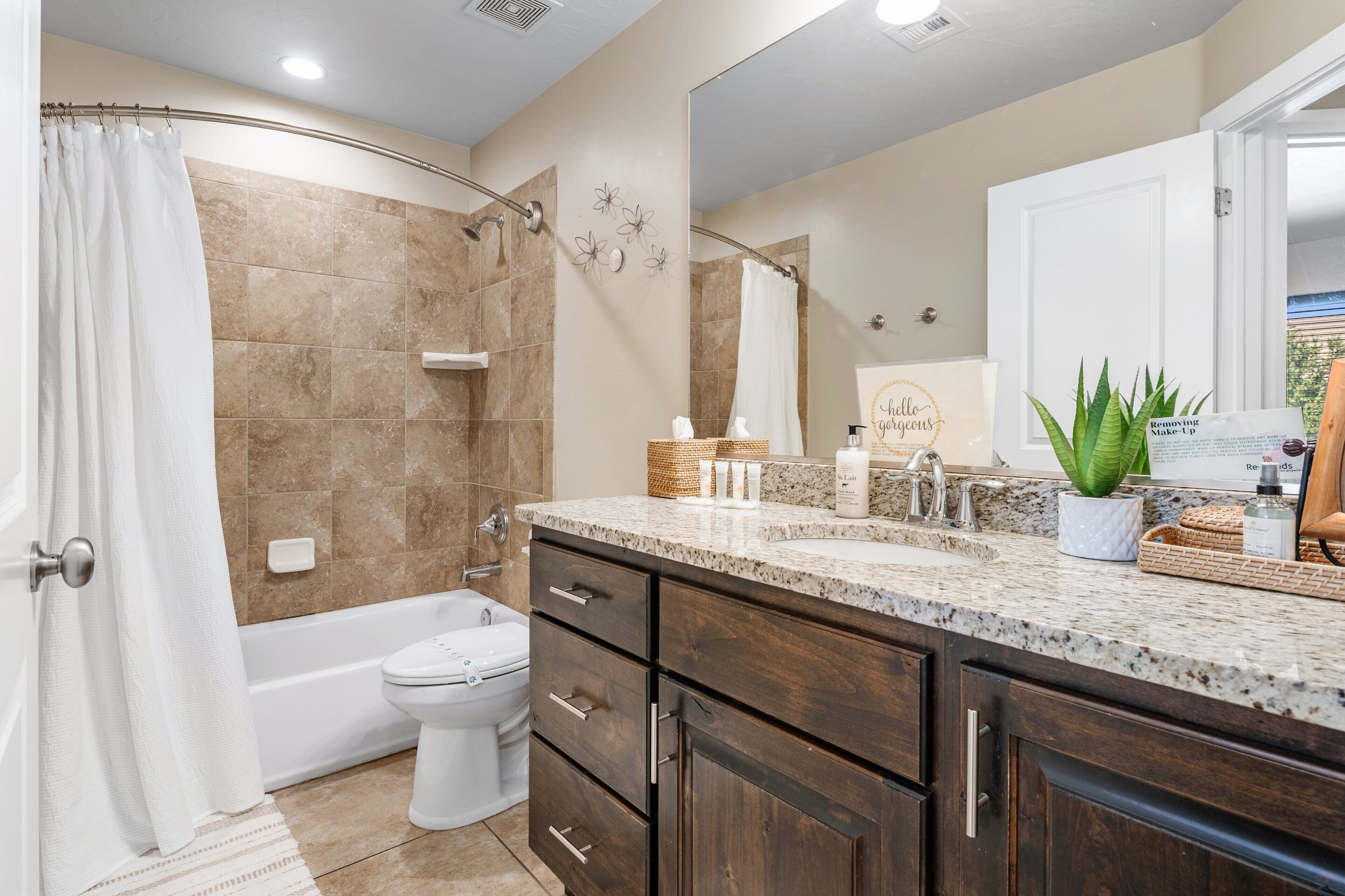 A modern bathroom with a shower, toilet, and vanity.