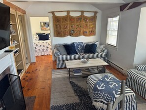 A cozy living room with a striped sofa, a coffee table, and a patterned rug.