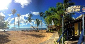 A beachside property with a sign for 'Thomas King Club' offering tours and boat trips.