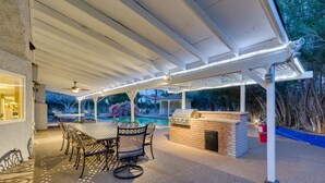 An outdoor patio with a pool, a barbecue area, and a covered seating area with a table and chairs. - Family Fun, Pickleball, Pool/Spa, Water slide (Las Vegas)