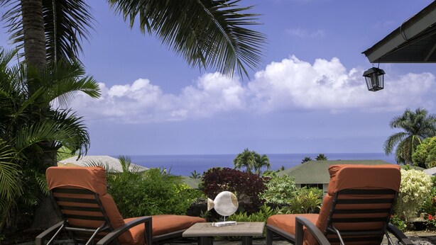 Two rocking chairs with cushions, a small table, and a decorative fan. - Hale Alaula - Ocean View: Private Home Near Kona Town w/Spa, AC, Spacious Lanai (Kailua Kona)