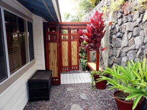 A small outdoor area with a wooden gate, a stone wall, and potted plants. - Hale Alaula - Ocean View: Private  Home Near Kona Town w/Spa, AC, Spacious Lanai (Kailua Kona)