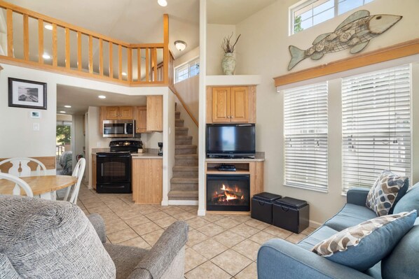 A spacious living area with a fireplace, a television, and a cozy seating area. - Cozy Retreat at CrossTimbers Marina (sperry)