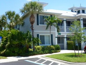 A multi-story building with a flat roof, balconies, and a parking lot. - Luxury 3 bed  Resort Style Amenities (Naples)