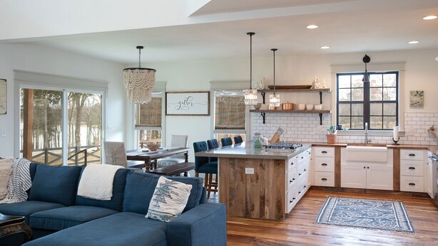 A modern kitchen with a central island, white cabinetry, and pendant lighting.