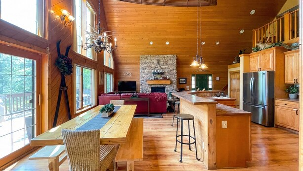 A spacious kitchen with wooden cabinets, a stone fireplace, and a large island. - 4BR Lodge Near Lake Geneva - Sitting Pool, Hot Tub, Sauna, Lake Views on 3 Acres (Lake Geneva)