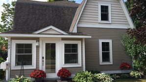 A two-story house with a front porch, a mailbox, and potted plants. - ★★★★★Charlevoix 5 Star-rated Cottage★★★★★ (Charlevoix)