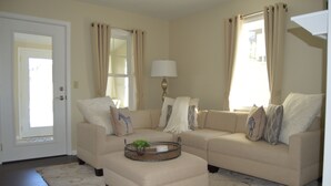 A living room with two beige sofas, a coffee table with a tray and plant, and a lamp. - ★★★★★Charlevoix 5 Star-rated Cottage★★★★★ (Charlevoix)