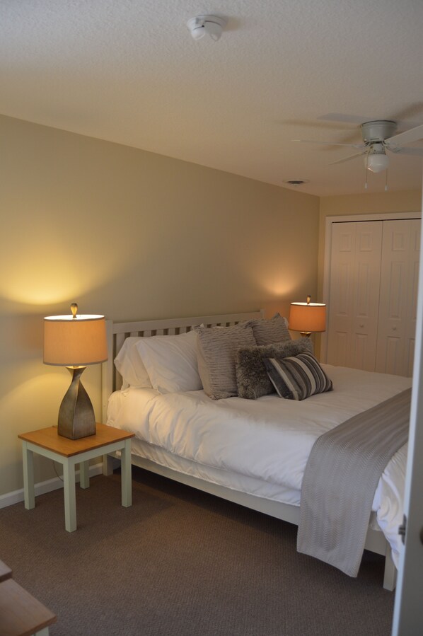 A bedroom with a bed, two bedside tables with lamps, a ceiling fan, and a door. - ★★★★★Charlevoix 5 Star-rated Cottage★★★★★ (Charlevoix)