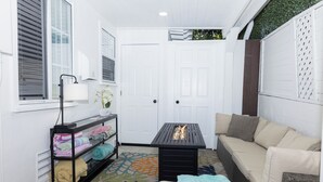 A cozy room with a sofa, a small table, a shelf with folded blankets, and a patterned rug. - 25% DisCount;  Rarely Available, OCean View & Sunsets; Steps to Sand (Laguna Beach)