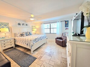 A bedroom with a bed, bedside tables, a chair, a television, and a window with curtains. - ON Siesta Key BEACH! Pool,Remodeled! 2bd2ba, sleeps 6, 3mins from door to sand   (Sarasota)