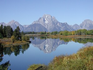 Eine Berglandschaft mit einem klaren See, der die Berggipfel spiegelt.