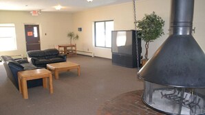 A living room with a fireplace, leather sofa, wooden coffee table, and a television. - 2 Bed 2 Bath Family Ski Condo (Pet Friendly!) (Dillon)