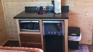 A compact kitchen with a microwave, a Danby refrigerator, and a coffee maker on the countertop. - Crooked Creek Ranch Cabin 2 (Hamilton)