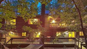 Un bâtiment en bois à deux étages, doté d’un balcon, d’un hamac et d’une terrasse en bois.