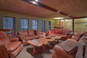 A cozy living room with leather sofas, a coffee table, and a fireplace. - Kobey's Ski Lodge - Sleeps 33 - Theater Room - Game Room - Golf - Dogs Welcome (Pinetop)