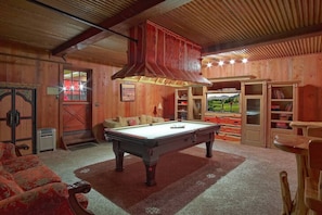 A pool table in a room with wooden walls, a sofa, and a bookshelf. - Kobey's Ski Lodge - Sleeps 33 - Theater Room - Game Room - Golf - Dogs Welcome (Pinetop)