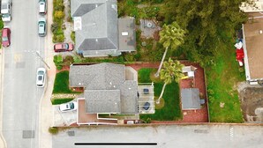 An aerial view of a residential area with multiple houses, a street, and parked cars. - Bright and Colorful - Family Friendly!  Short walk to the Best Beaches in Town! (Santa Cruz)