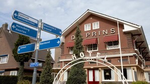 Un hotel con un cartel que indica indicaciones hacia lugares cercanos.