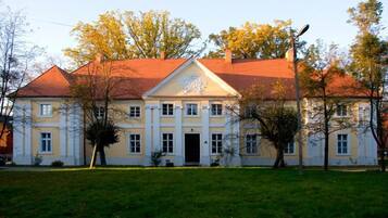 A large, two-story building with a symmetrical facade, a central entrance, and a red-tiled roof.
