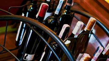 A wine rack with multiple bottles, some with corks, and a wooden cabinet in the background.