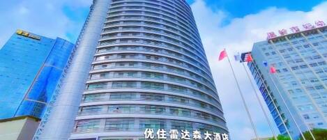 A tall, curved hotel building with a prominent entrance and signage.
