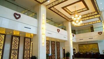 Un hall de hotel con techo alto, iluminación decorativa y adornos en forma de corazón.