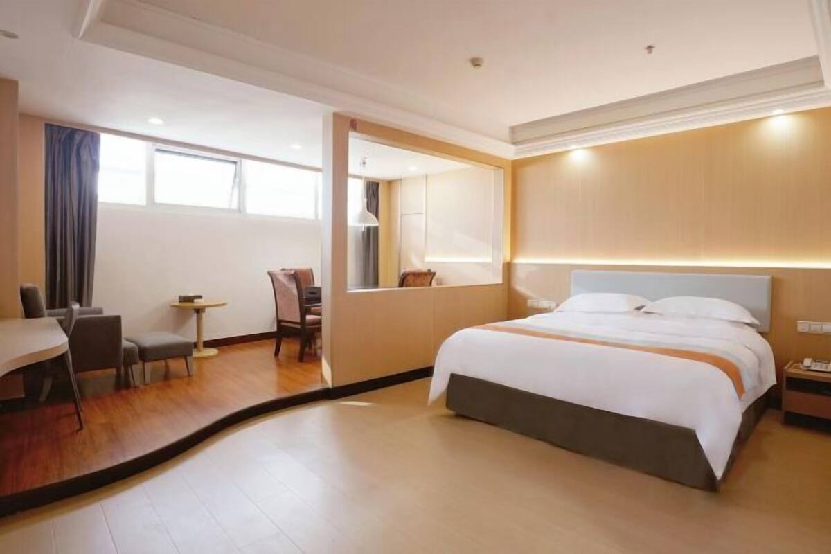 Una habitación de hotel con una cama grande, un escritorio y una silla.