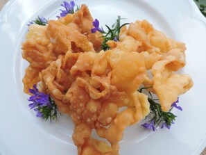 Un plato de masa frita con flores moradas.