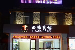 Un letrero de hotel con el nombre 'XITANG HOTEL' y una fachada decorativa.