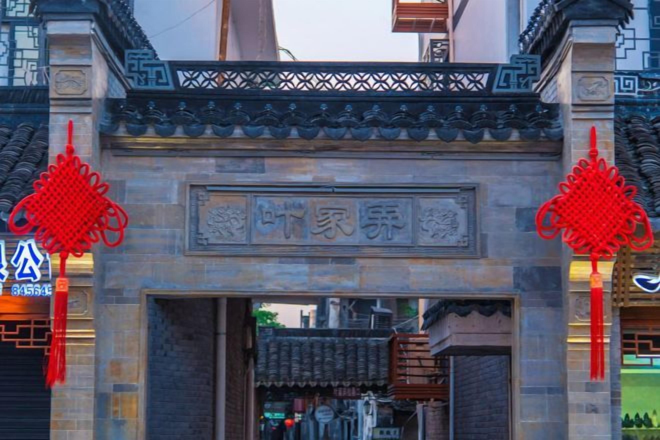 A traditional gate with a stone inscription and red decorative elements.