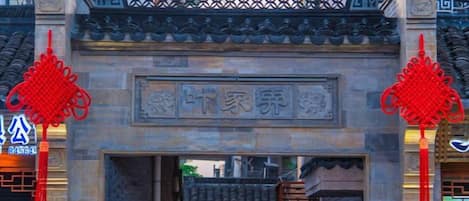 Una puerta tradicional con una inscripción de piedra y detalles decorativos rojos.