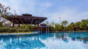Ein Pool mit Pavillon und umgebender Bepflanzung.