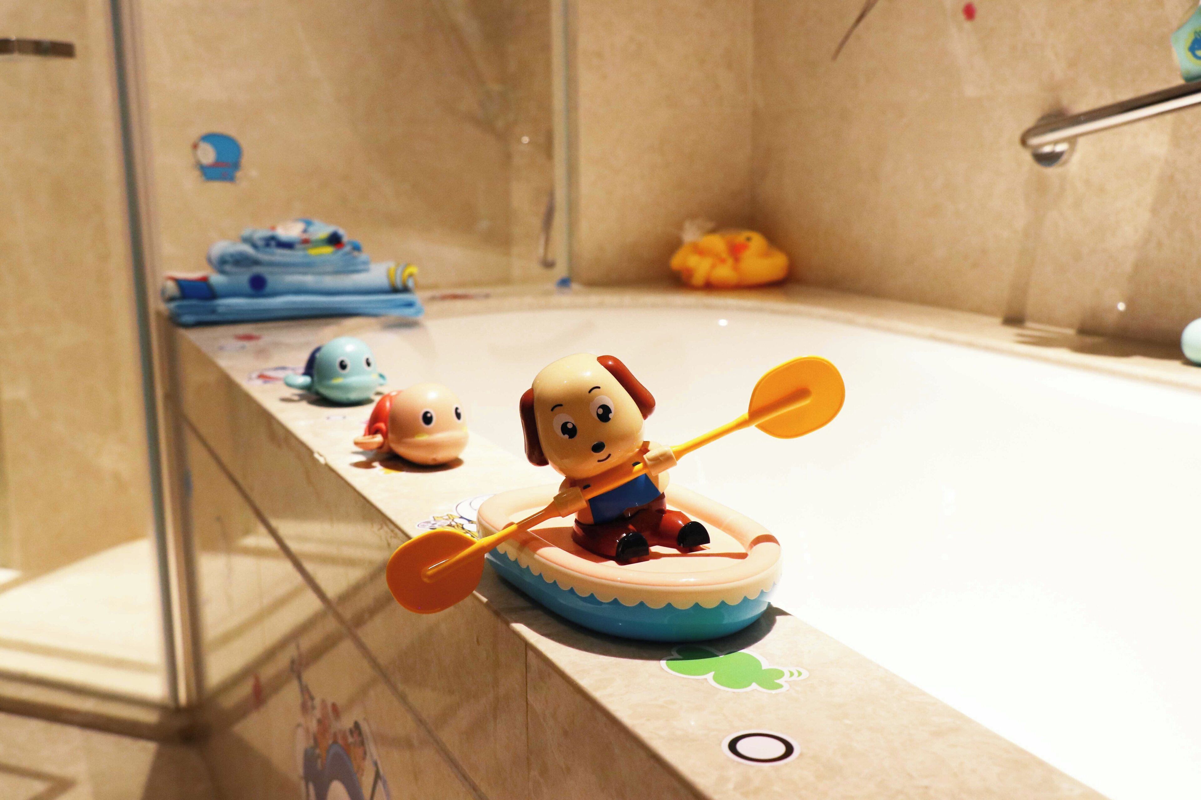 Une baignoire avec un petit bateau jouet et une pagaie.