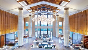 Un hall d’entrée spacieux, doté de hauts plafonds, de grandes fenêtres et d’un espace salon central.