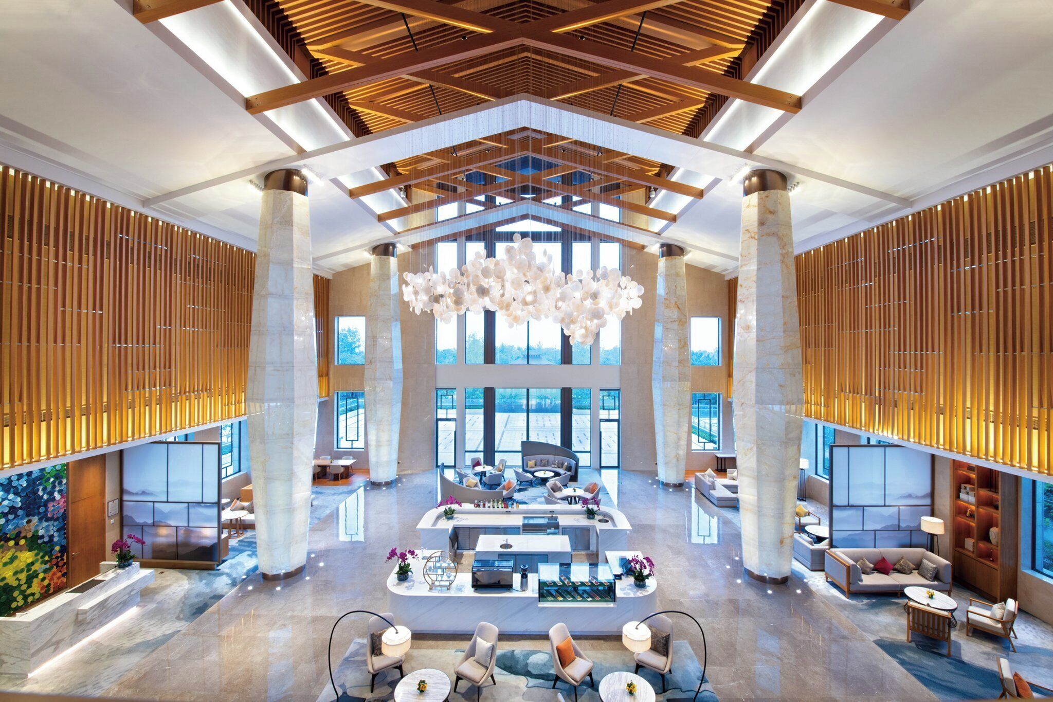 A spacious lobby with high ceilings, large windows, and a central seating area.