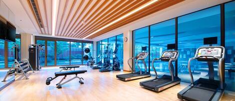 A modern gym with treadmills, a bench press, and weight machines.