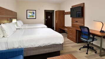 A hotel room with two beds, a desk, a chair, a TV, and a wardrobe.