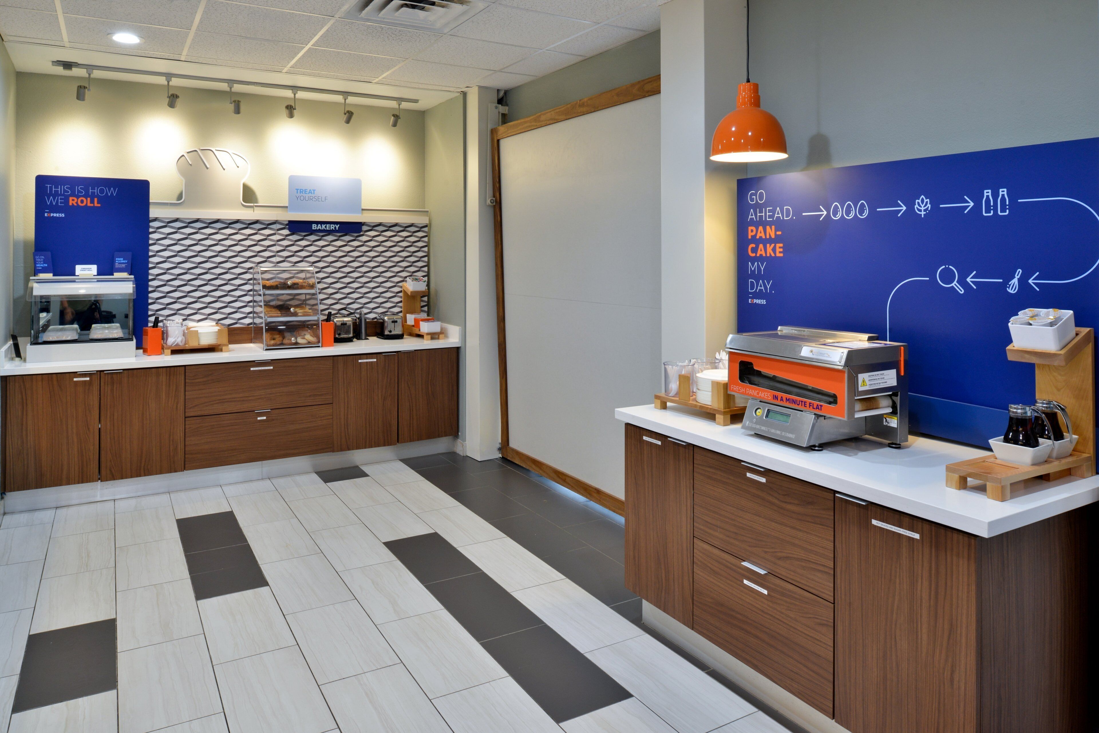 A modern kitchen area with a bakery section, a coffee machine, and a chalkboard with writing.