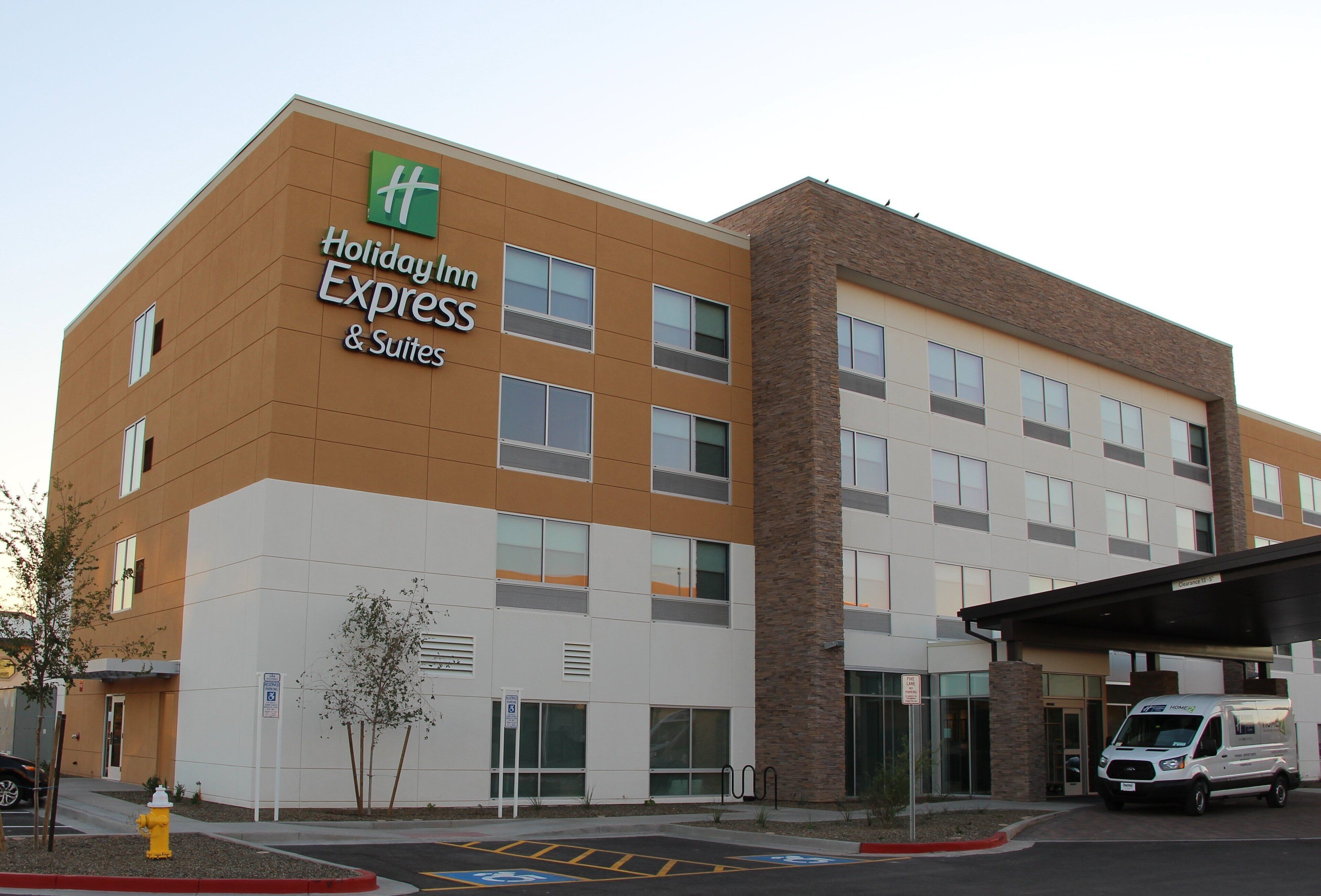 Un bâtiment de l’hôtel Holiday Inn Express, avec une entrée bien visible, une voie d’accès pour les véhicules d’urgence et un espace de stationnement.