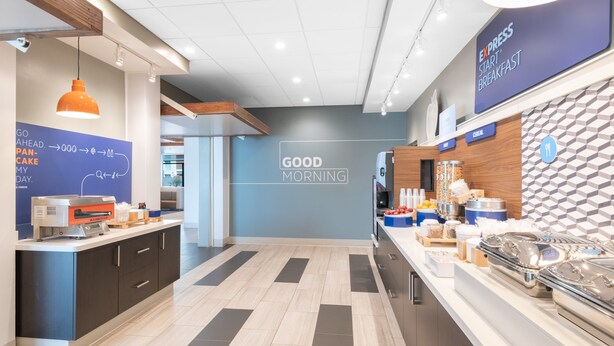 A modern breakfast area with a sign reading "EXPRESS START BREAKFAST" and a "GOOD MORNING" sign on the wall. - Holiday Inn Express & Suites Phoenix - Airport North by IHG (Phoenix)