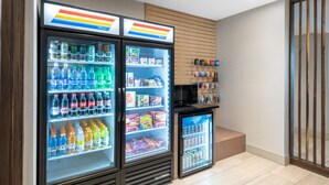 A vending area with three beverage dispensers, a microwave, and a small refrigerator. - Holiday Inn Express & Suites Phoenix - Airport North by IHG (Phoenix)