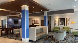 A modern lobby with a reception desk, seating area, and a bar. - Holiday Inn Express & Suites Phoenix - Airport North by IHG (Phoenix)