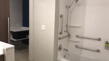 A modern bathroom with a walk-in shower, grab bars, and a bathtub.