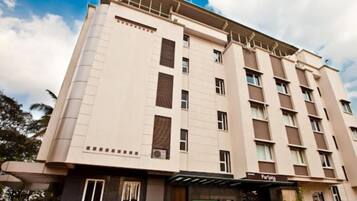 A multi-story hotel with a flat facade, large windows, and a covered entrance area.