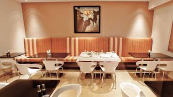A modern dining area with a long table, white chairs, and a bench.
