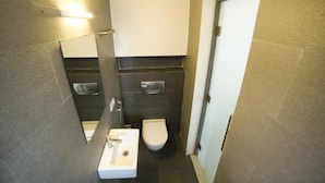 Un bany amb un lavabo blanc, un vàter i un mirall.